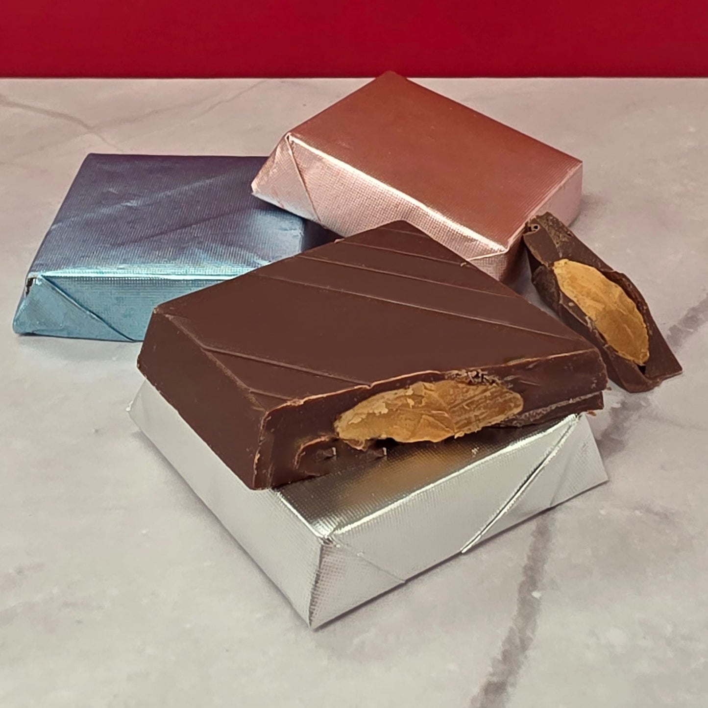 Milk chocolate piece filled with a whole roasted almond, handmade by TAWDI in Anaheim