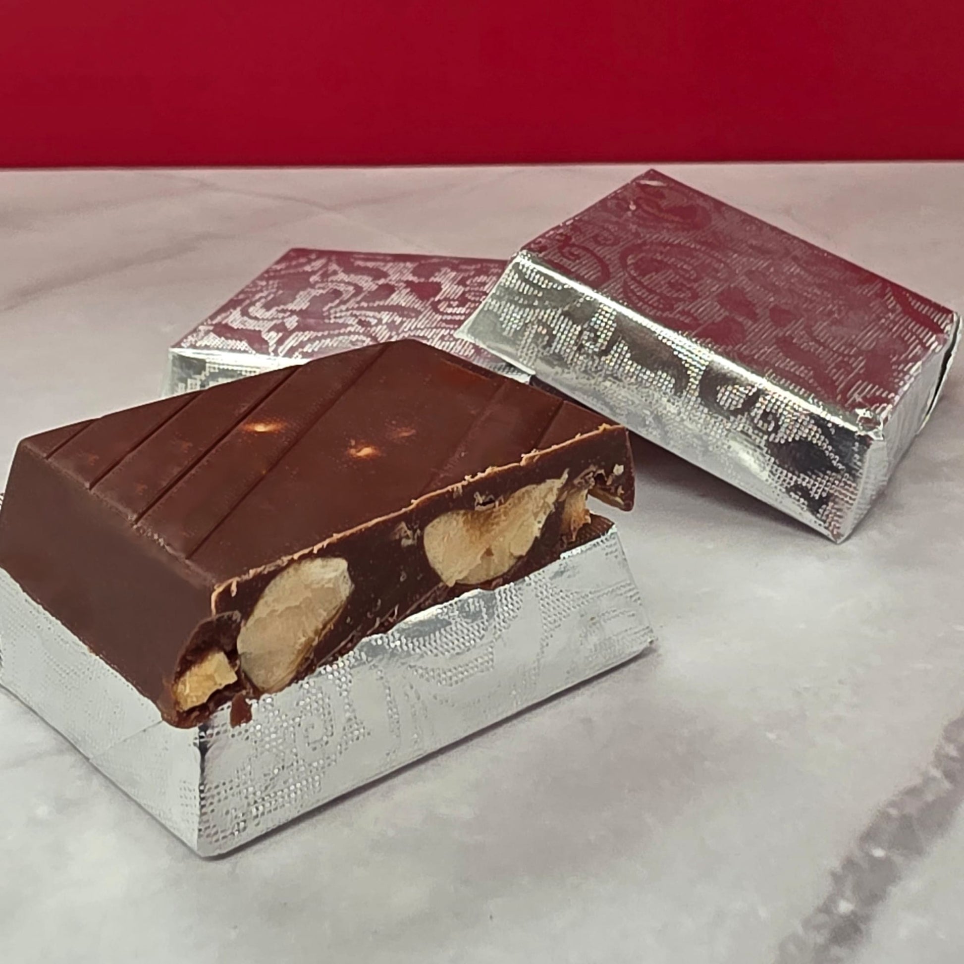 Milk chocolate piece with a whole roasted hazelnut center, handmade by TAWDI