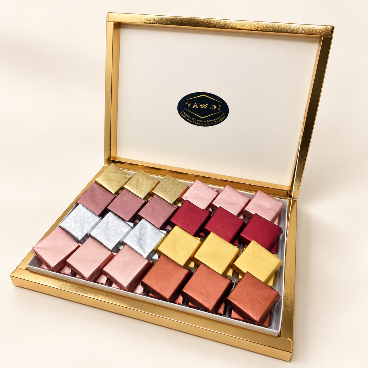 Gold TAWDI Signature Box, 48-piece size with two layers, lid open, angled view (top layer shown)
